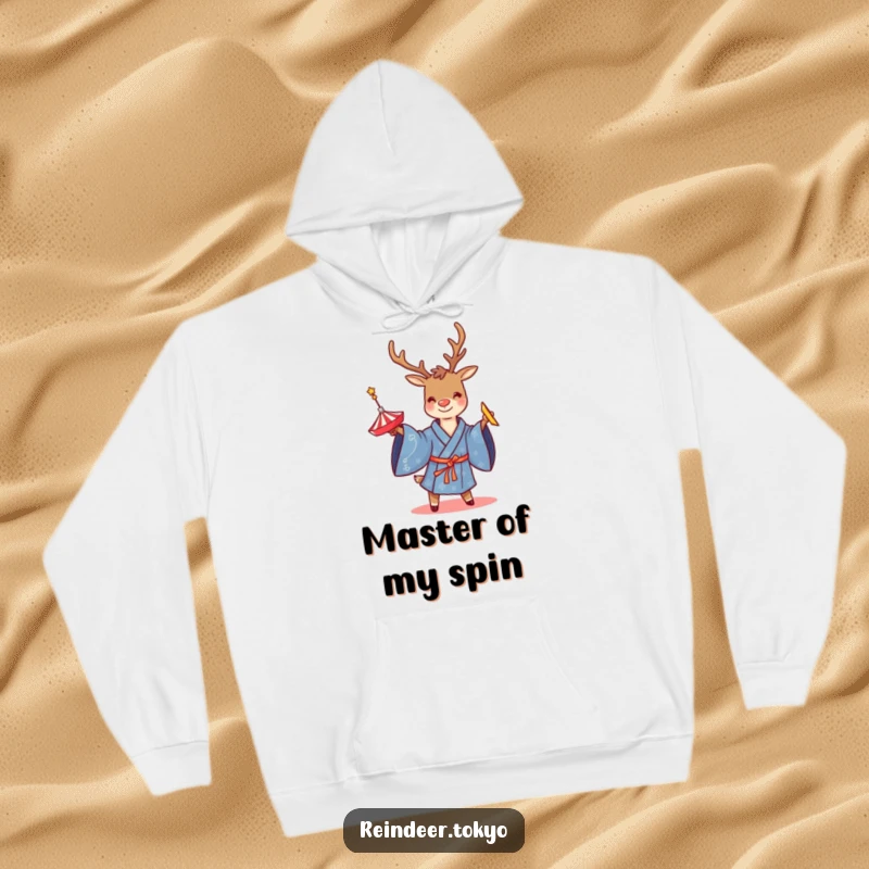 Funny hoodie showing a smiling reindeer in a blue kimono, focused on twirling a spinning top, blending comfort with playful entertainment.